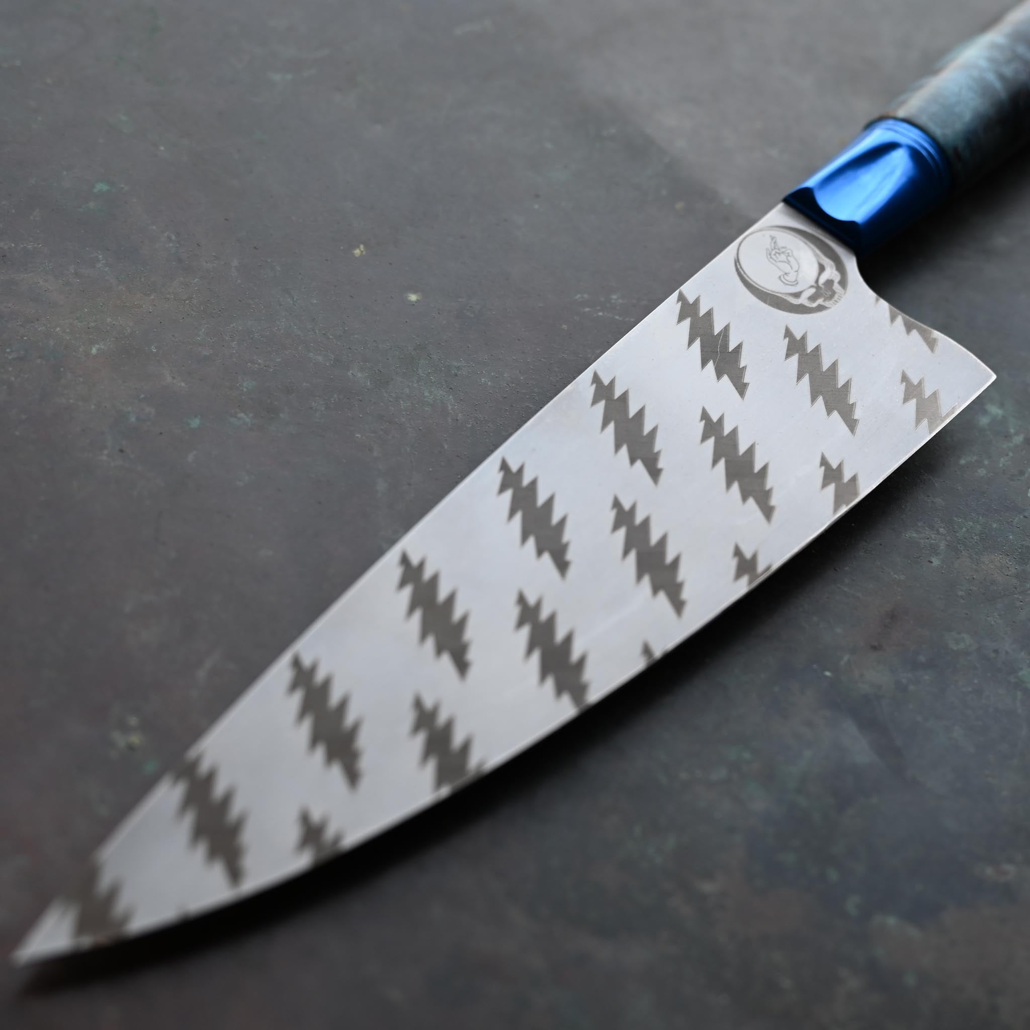 GRATEFUL DEAD CHEF KNIFE, BLUE BOLSTER, TIE DYE WOOD HANDLE, ON CONCRETE
